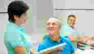 Врач показывает пациенту макет челюсти с установленным имплантом